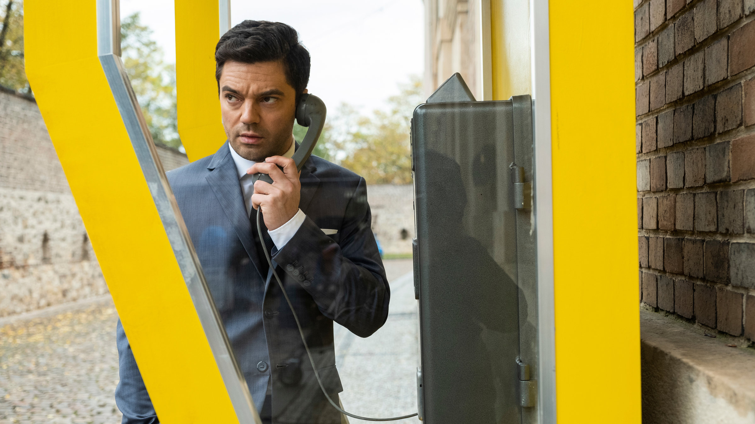 "Spy City (3)": Fielding Scott (Dominic Cooper) steht in einer gelben Telefonzelle.