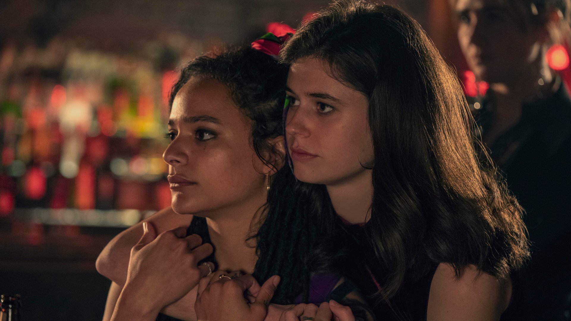 "Conversations with Friends - Diamanten": Frances (Alison Oliver) und Bobbi (Sasha Lane) halten sich in einer Bar im Arm. Frances steht dabei hinter Bobbi und schaut ihr über die Schulter.