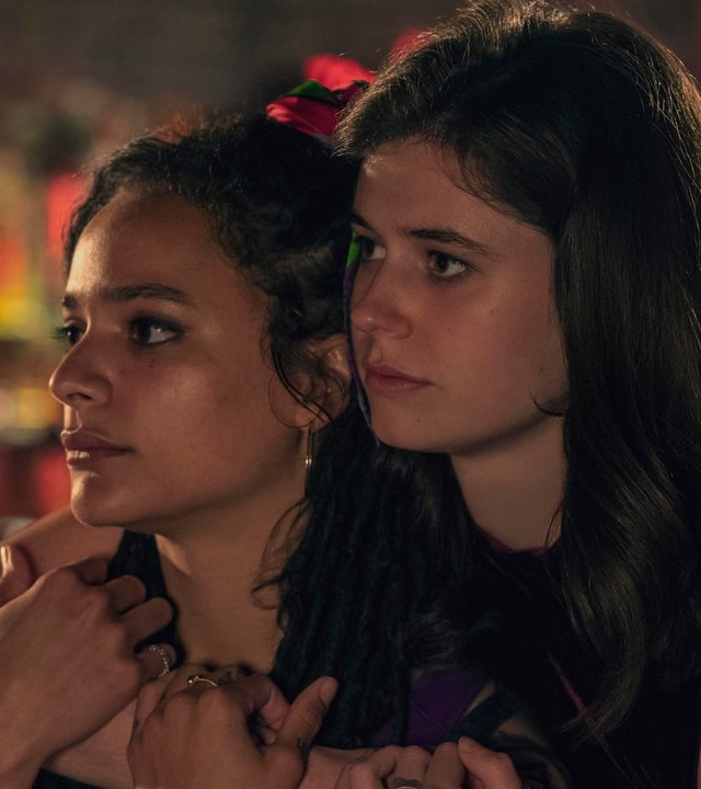 "Conversations with Friends - Diamanten": Frances (Alison Oliver) und Bobbi (Sasha Lane) halten sich in einer Bar im Arm. Frances steht dabei hinter Bobbi und schaut ihr über die Schulter.