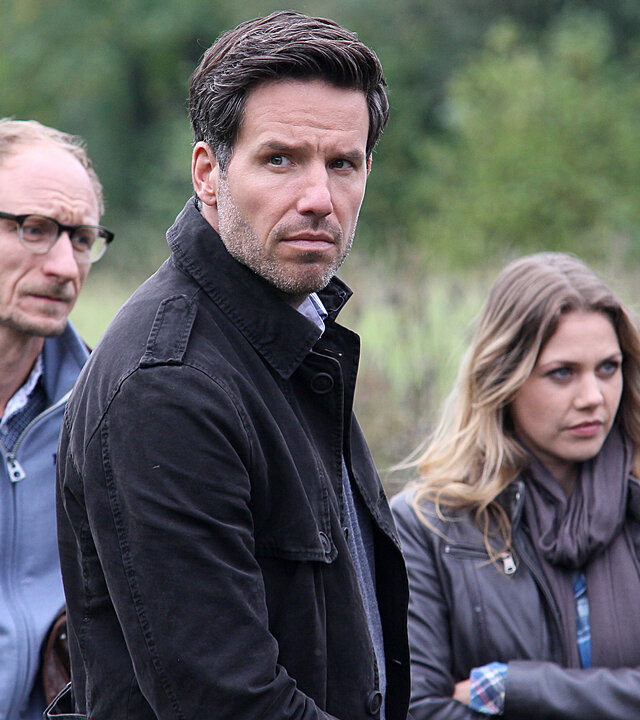 "Mordsfreunde": Kai Ostermann (Michael Schenk) und das Ermittler-Duo Oliver von Bodenstein (Tim Bergmann) und Pia Kirchhoff (Felicitas Woll) stehen auf einer Wiese.