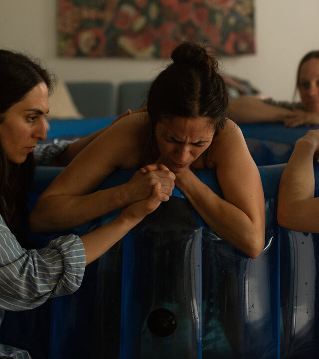 "PUSH - I judge, you judge, we judge": Malia (Lodi Doumit) hält die Hand ihrer Schwester Alice (Pinar Erincin), die in ihrem Wohnzimmer auf dem Rand eines Geburtsbeckens liegt. Daneben sitzt Nalan Arzouni (Mariam Hage), die die Geburt betreut. Im Hintergrund sitzen Greta Malinger (Lydia Lehmann) und Christiane (Christiane Hammerl) ebenfalls an dem Becken.