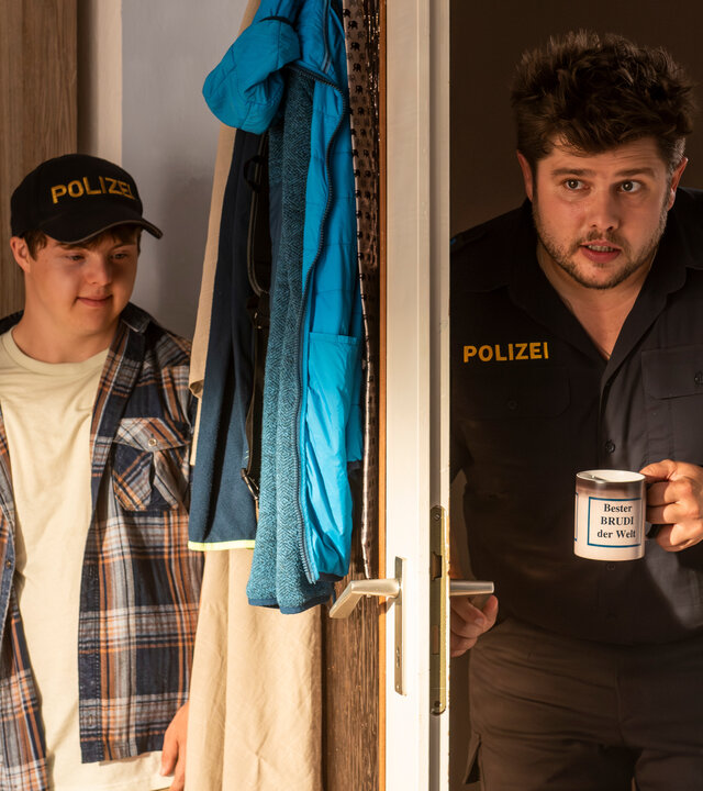 "Marie fängt Feuer - Brüder": Fritz (Sebastian Friz) öffnet mit einer Tasse Kaffee in der Hand die Tür zum Zimmer seines Bruders Eddy (Benjamin Raue), der sich hinter der Tür versteckt.