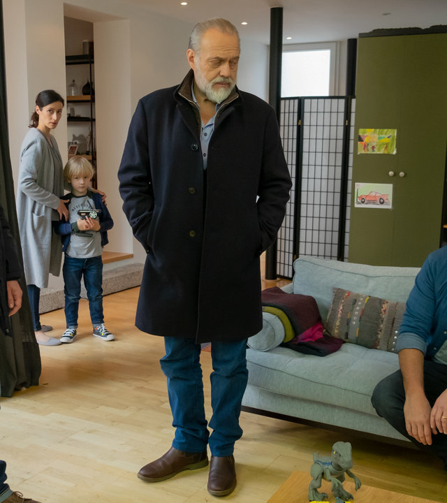 "Der Alte - Verantwortung": Tom Kupfer (Ludwig Blochberger) und Richard Voss (Jan-Gregor Kremp) stehen bei Alex Volkmann (Simon Böer) im Wohnzimmer, um sich mit ihm zu unterhalten. Marie Volkmann (Katrin Anne Heß) steht im Hintergrund bei ihrem kleinen Kind Max (Komparse).