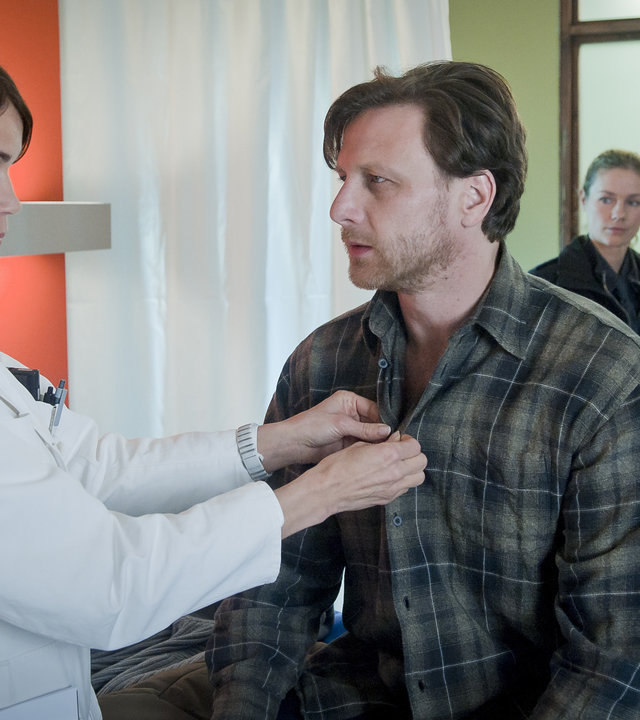 "Notruf Hafenkante - Hilfe für die Reiterstaffel": Dr. Jasmin Jonas (Gerit Kling) knöpft das Hemd von Christian Olsen (Hendrik Duryn) zu, der vor ihr auf dem Behandlungstisch sitzt. Franzi (Rhea Harder) und Hans (Bruno F. Apitz) beobachten die beiden.