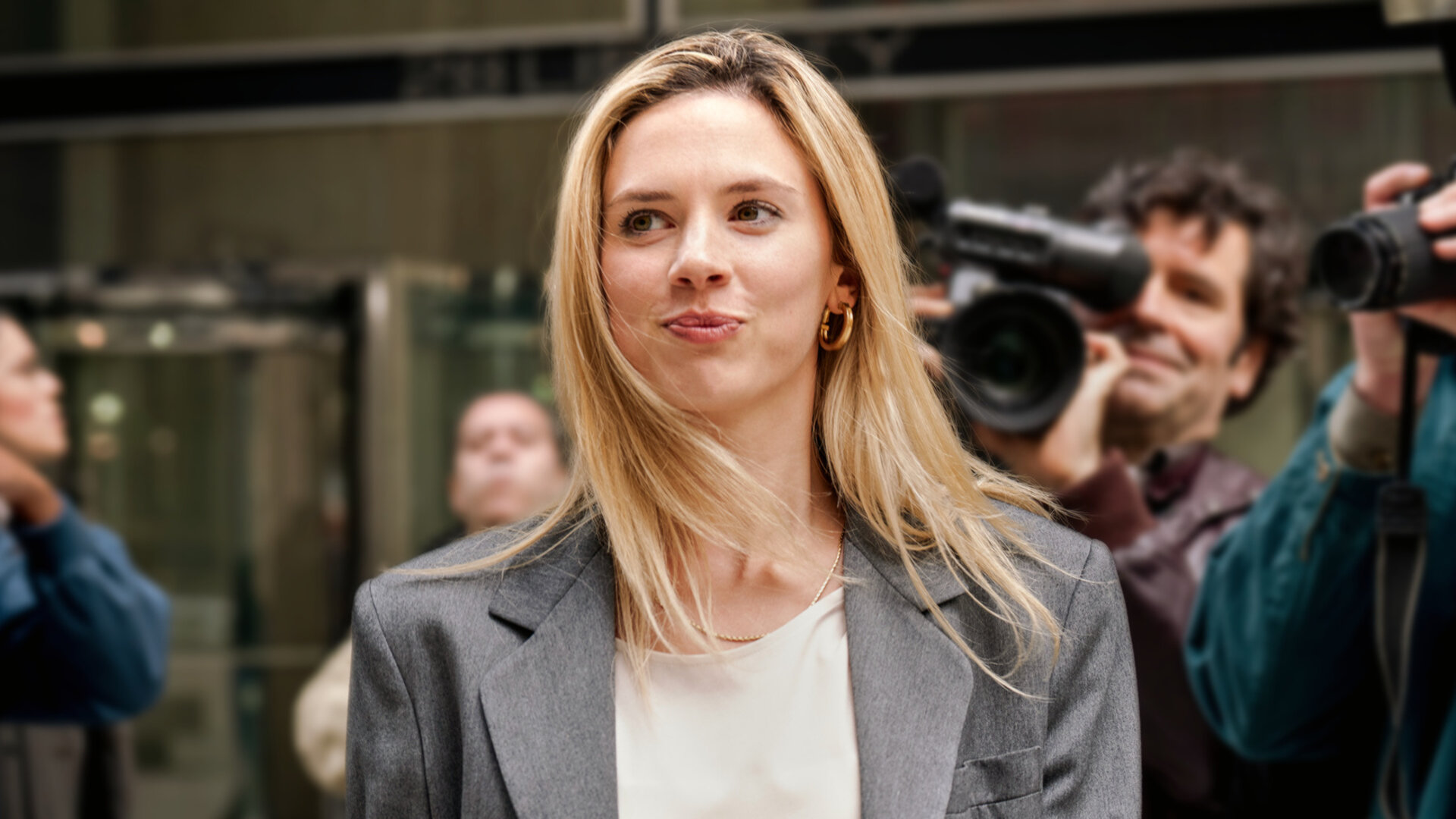 "Maxima - Paparazzi": Maxima (Delfina Chaves) kommt aus einem Gebäude und ist umgeben von Fotografen und Kameramännern (Komparsen).