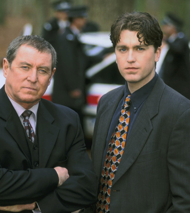 "Inspector Barnaby - Treu bis in den Tod": Barnaby (John Nettles) und Troy (Daniel Casey) stehen im Wald an einem Tatort nebeneinander und schauen in die Kamera. Im Hintergrund ist ein Polizeiwagen sowie mehrere Polizisten zu sehen. finiert)