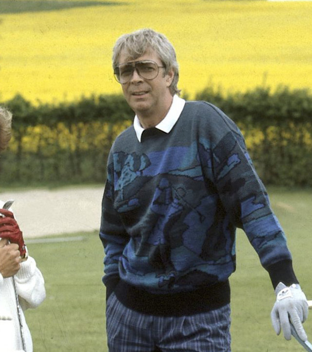 "Zwei Münchner in Hamburg - Warteschleifen": Julia (Uschi Glas) und Van Daalen Junior (Volkert Kraeft) spielen gemeinsam Golf. Im Hintergrund ist ein gelbes Rapsfeld zu sehen.