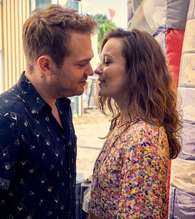 "Like a Loser - Ist das was Ernstes?": Julian (Ben Münchow) und Marie (Tinka Fürst) sind kurz davor, sich zu küssen. Sie stehen dabei hinter einer Hüpfburg auf dem Schulhof.