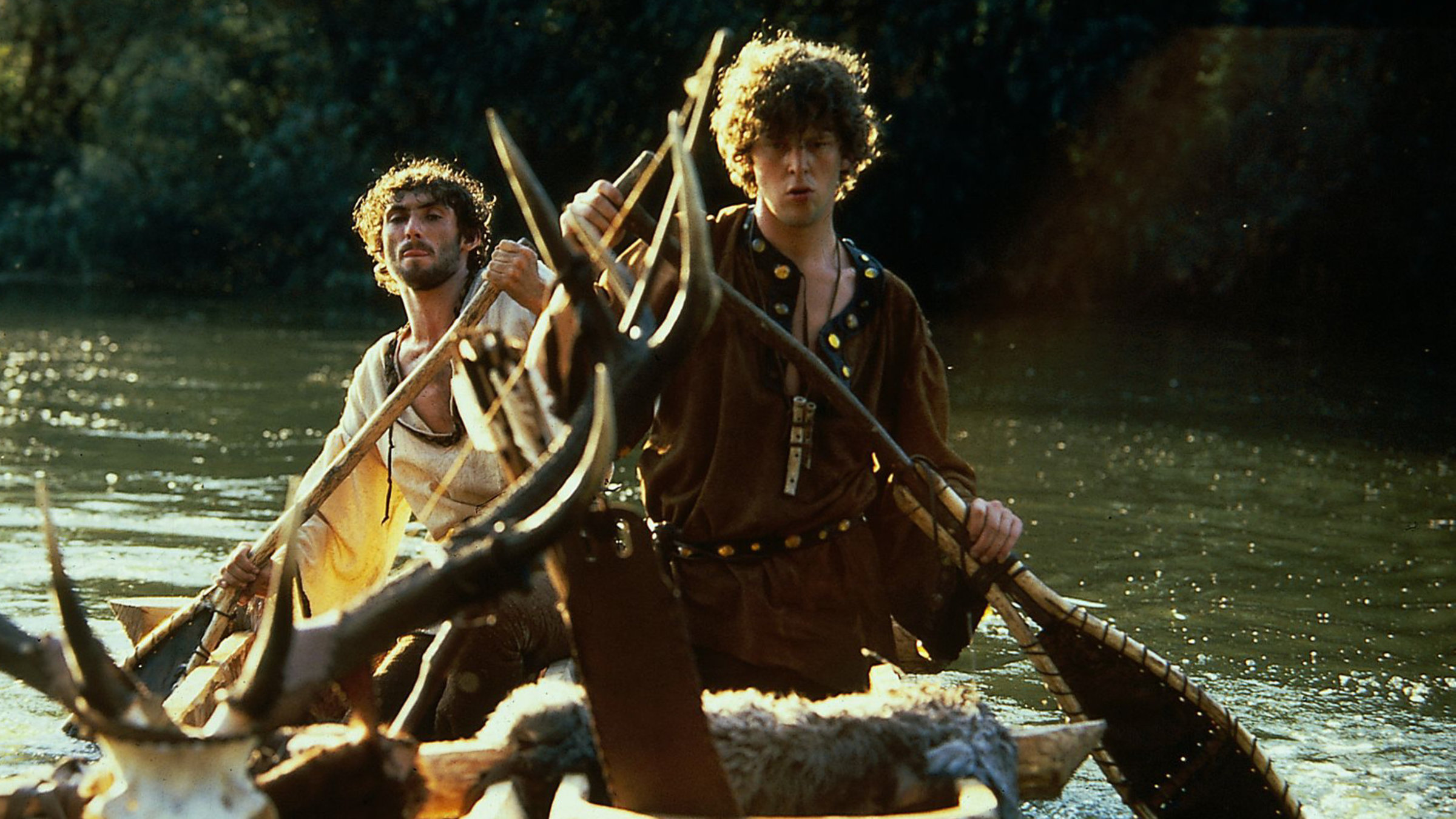 "Der treue Johannes": Prinz Martin (Remi Martin) und Johannes (Vladimir Hajdu) sitzen auf einem kleinen Boot und rudern einen Fluss entlang.