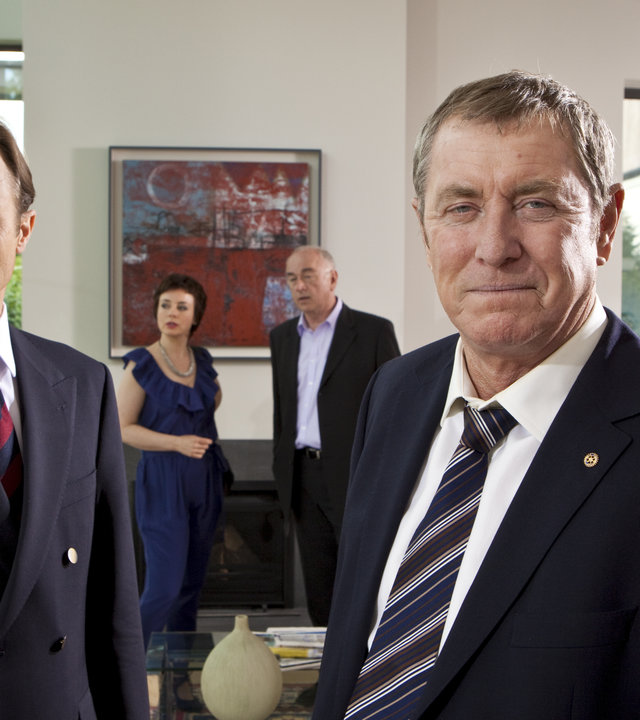 "Inspector Barnaby - Eine Schande für das Dorf": Major David Walsh (David Annen), Liz Gerrard (Amanda Drew), Norman Swanscombe (Peter Egan), DCI Tom Barnaby (John Nettles) und Clifford Bunting (Alistair Petri) stehen alle in einem Wohnzimmer verteilt.