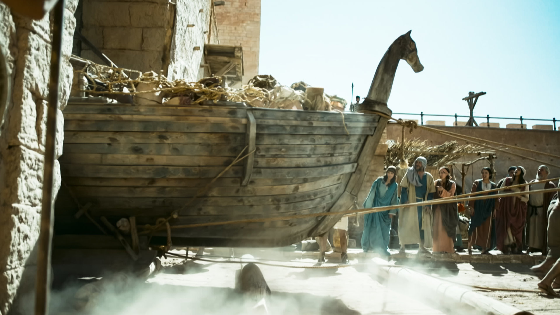 "Die glorreichen 10 - Die legendärsten Schiffe der Geschichte": Die Trojaner ziehen ein mit Schätzen beladenes Schiff durch ihr Stadttor. Den Bug ziert ein hölzerner Pferdekopf.