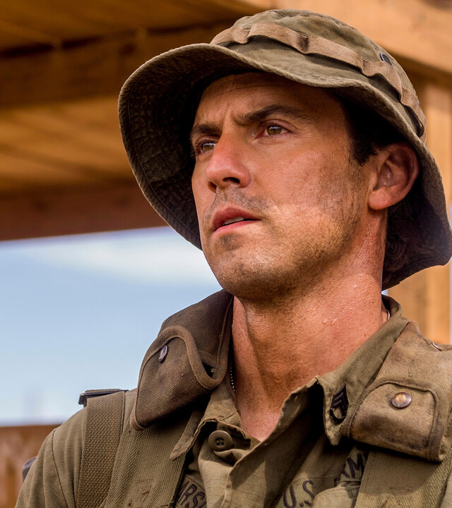 "This Is Us - Sonntagskind": Jack (Milo Ventimiglia) steht auf einem Gelände. Er trägt eine Militäruniform, einen passenden Rucksack über den Schultern sowie einen passenden Hut auf dem Kopf. Sein Gesicht ist leicht mit Staub bedeckt, und er blickt ernst nach vorn.