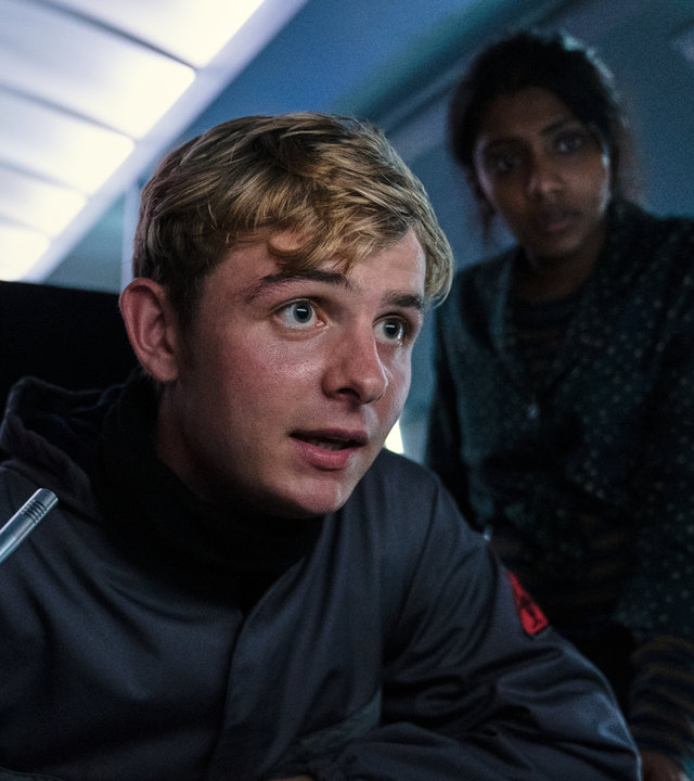 "Alex Rider - Schlag": Alex (Otto Farrant) und Sabina (Charithra Chandran) sitzen angespannt vor einem Kontrollpult.