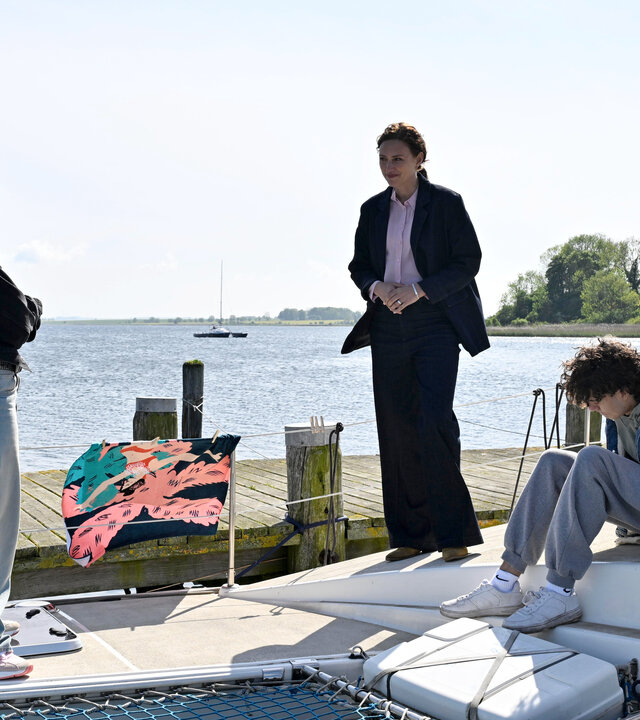 "SOKO Wismar - Verschwunden": Kommissarin Karoline Joost (Nike Fuhrmann) befragt die jungen Straffälligen Vivian (Lorna Zu Solms) und Ilan (Marven Suarez Brinkert) auf dem Katamaran der Bongarts, der zurzeit im Yachthafen liegt.