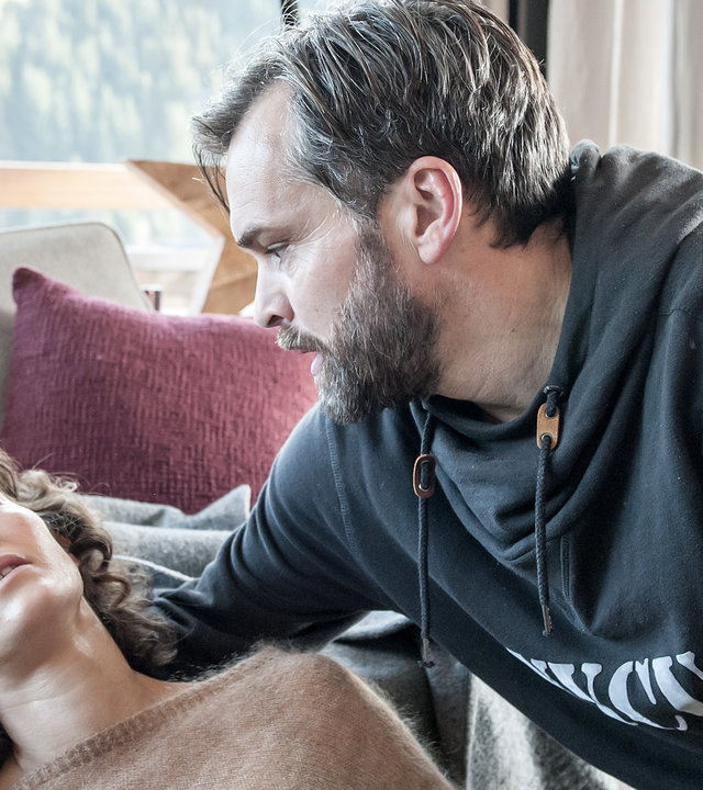 "Der Bergdoktor - Die Lebenden und die Toten (2)": Michaela Höffner (Margrit Sartorius) liegt bewusstlos im Wohnzimmer. Ihr Mann Sebastian (Ole Puppe) kniet besorgt neben ihr und hält sie im Arm.