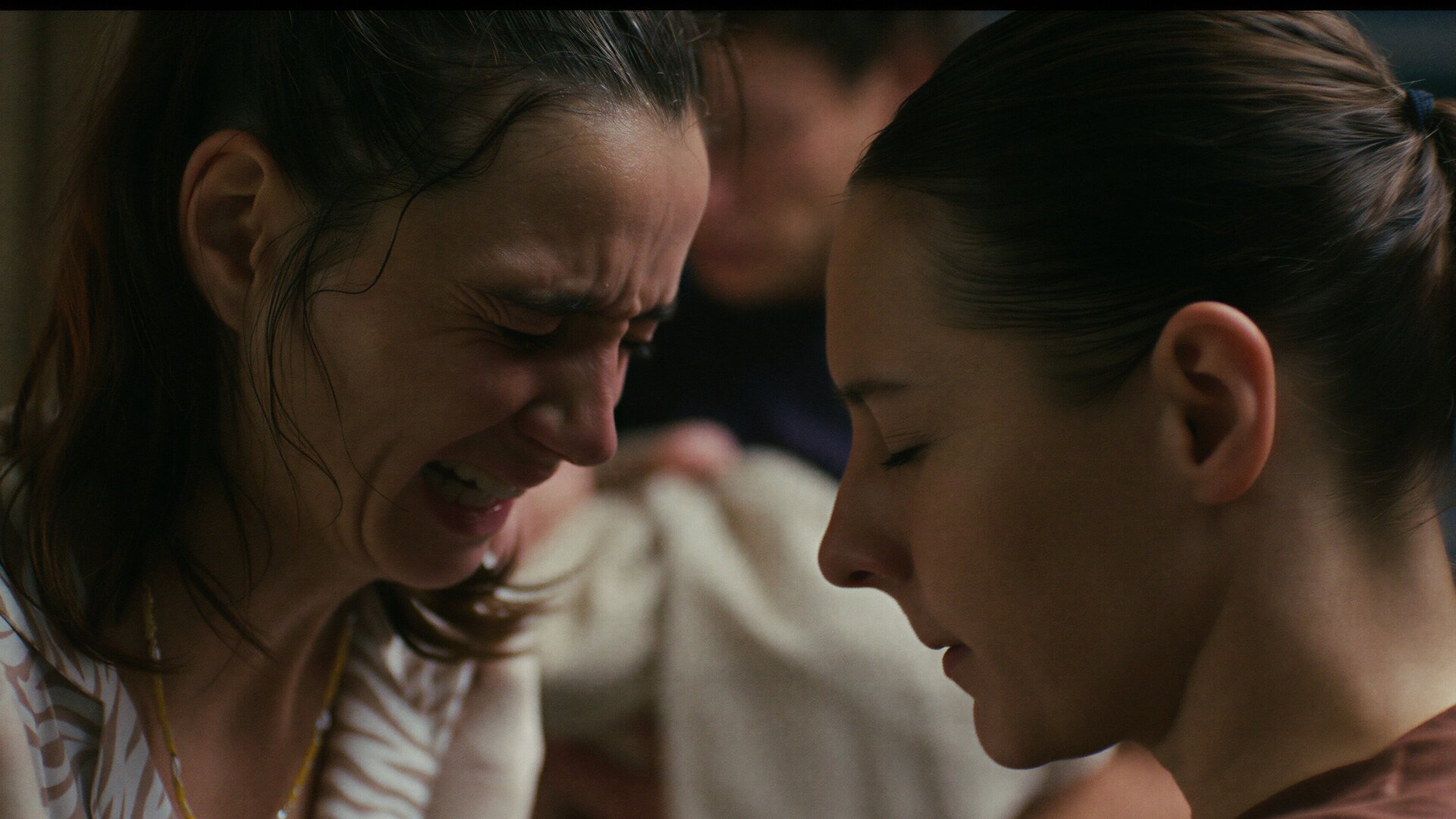 "PUSH - Schicht": Nahaufnahme: Mimi (Laura Balzer) und Elke (Marie Rosa Tietjen) sind fast Kopf an Kopf. Mimi weint und hat ein schmerzverzehrtes Gesicht. Elke strahlt Ruhe aus und blickt nach unten.