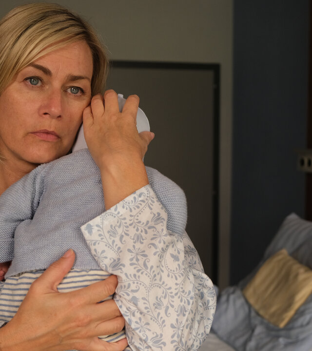 "Lena Lorenz - Mutterliebe": In einem Krankenzimmer steht Petra Hoffmann (Gesine Cukrowski) und hält ein Baby auf dem Arm. Sie blickt nachdenklich.