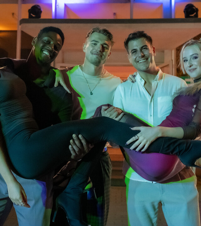 "Blutige Anfänger - Die letzte Ermittlung": Tulani (Ben Andrews Rumler), Phillip (Eric Cordes) und Umut (Uğur Ekeroğlu) stehen nebeneinander vor dem Eingang der PFH. Tulani hält Charlotte (Cheyenne Pahde) auf seinen Armen, Umut Anastasia (Luise Emilie Tschersich). Alle grinsen fröhlich. Es ist dunkel.