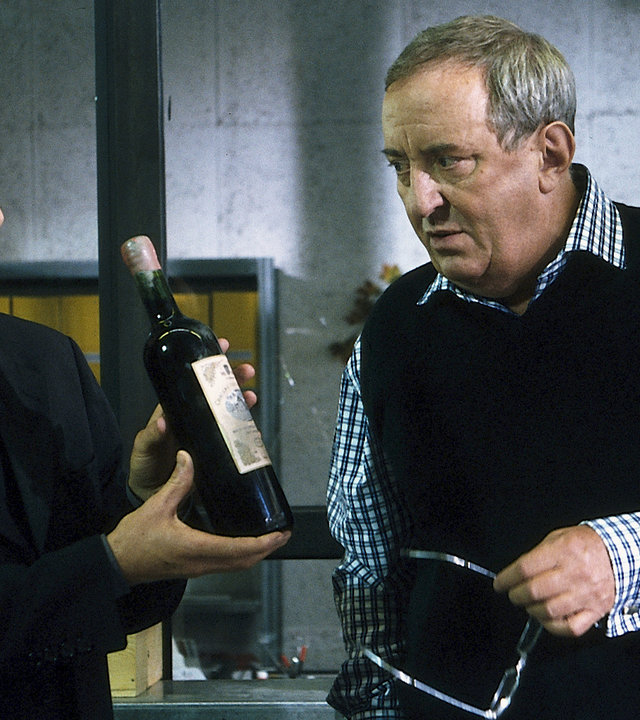 "Der letzte Zeuge - Bitter im Abgang": Dr. Robert Kolmaar (Ulrich Mühe) zeigt dem Weinkenner Thomas Irion (Vadim Glowna) eine Flasche, die er begutachten soll.