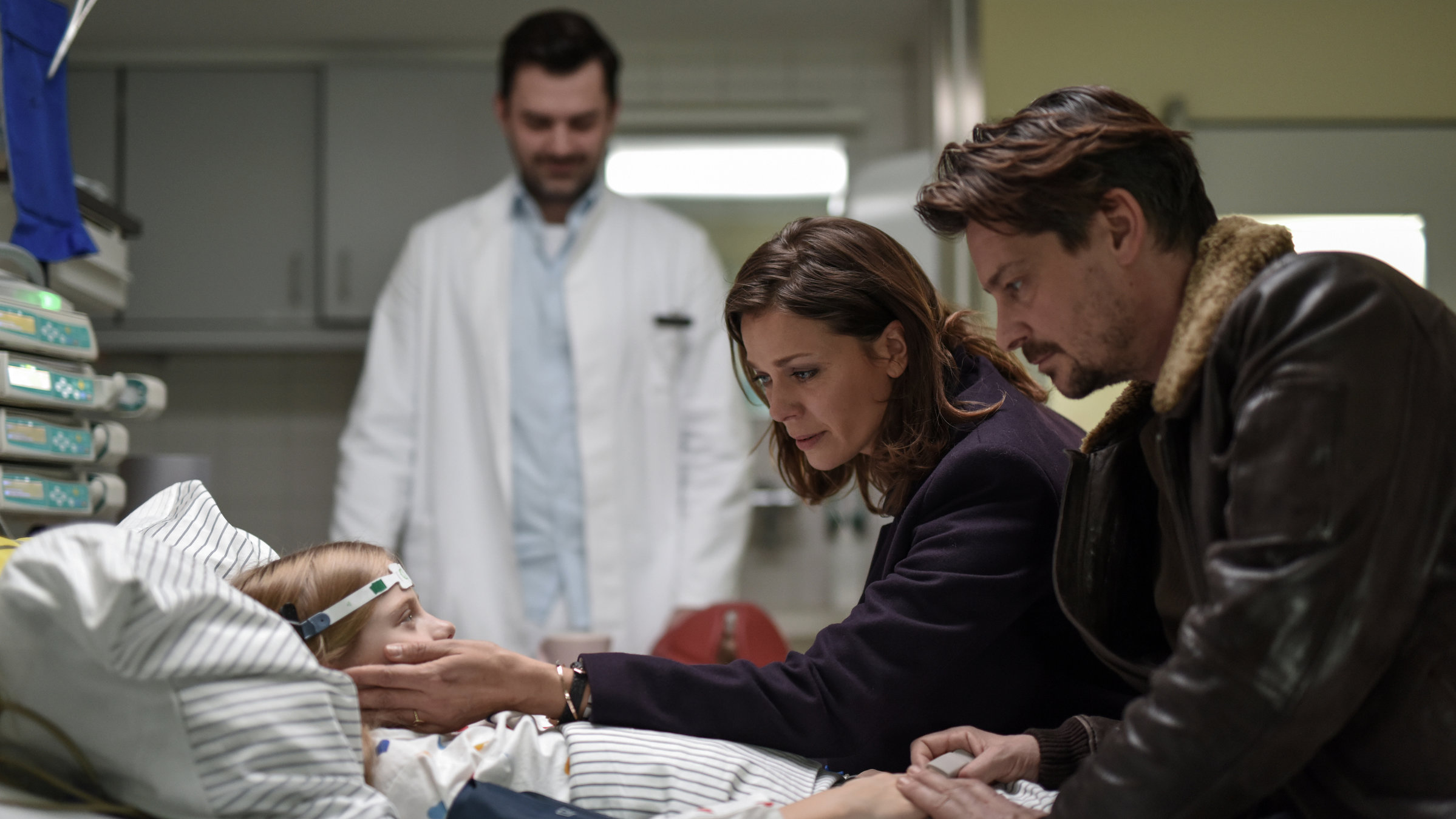 "Reich oder tot": Claire (Jessica Schwarz) und Kessel (Fritz Karl) sitzen bei Ruby (Cya Emma Blaack) am Krankenbett.