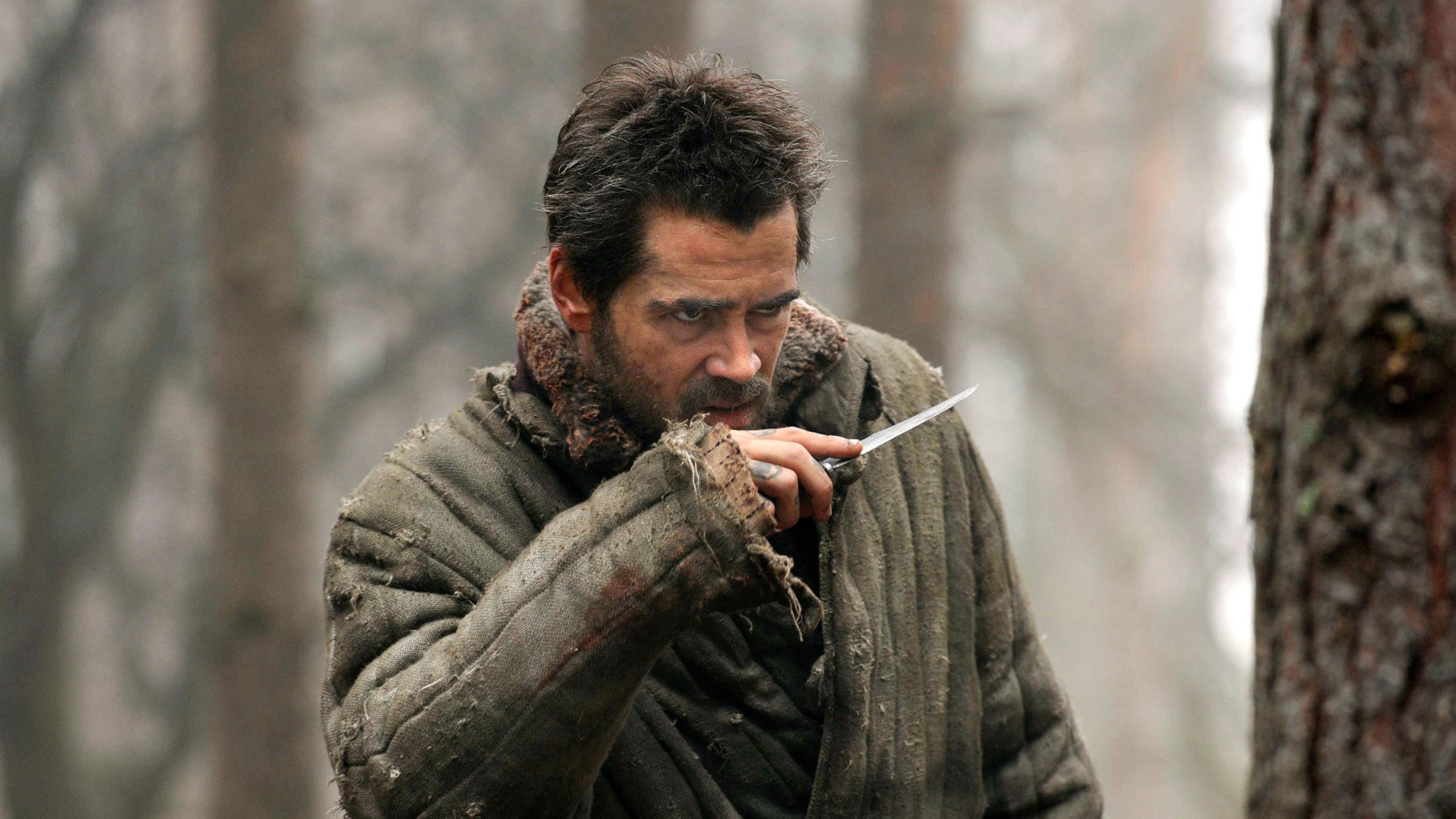 "The Way back - Der lange Weg" - Der Schwerverbrecher Valka (Colin Farrell) im Freien, er hält ein Messer in der Hand.