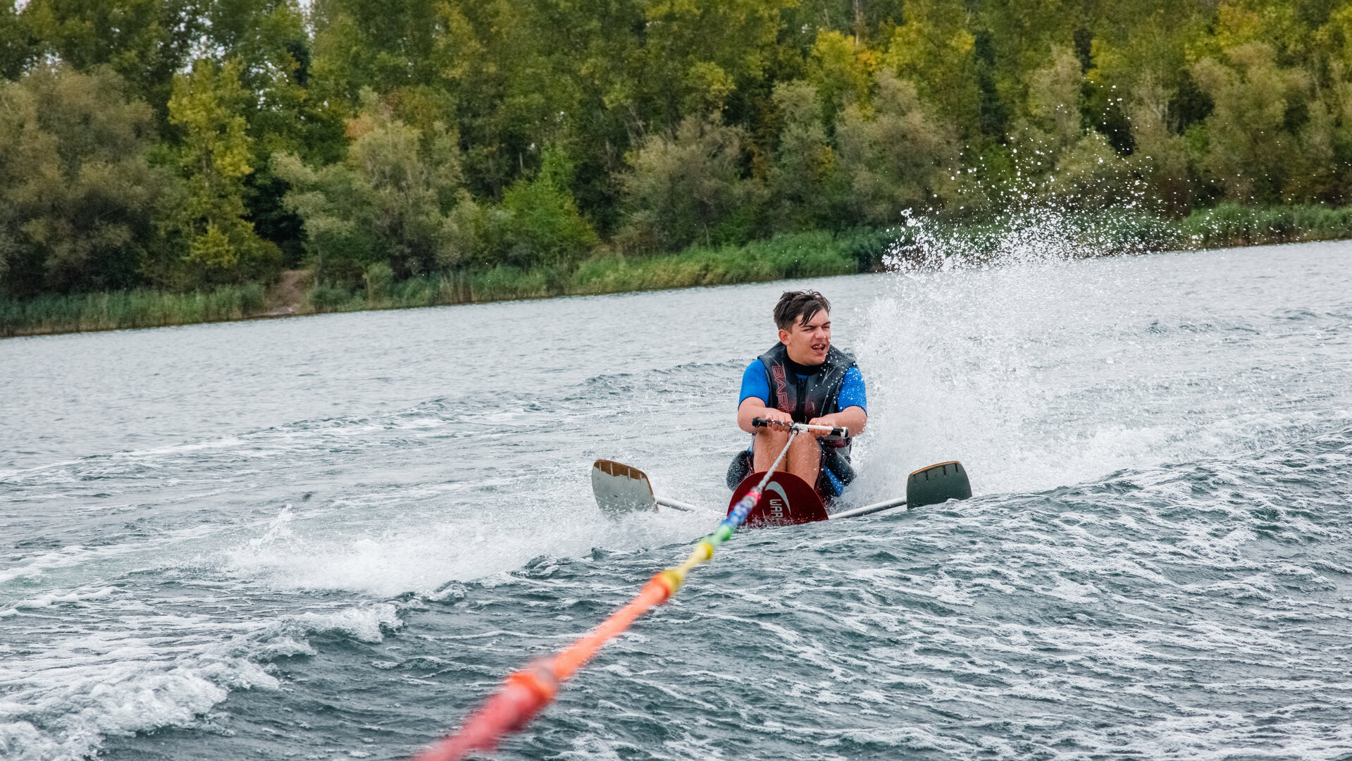 "einfach Mensch - Ole Rehwald: Auf Wasserski in Halle": Ole Rehwald hält eine Schleppleine und fährt im Sitzen Wasserski.