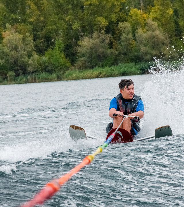 "einfach Mensch - Ole Rehwald: Auf Wasserski in Halle": Ole Rehwald hält eine Schleppleine und fährt im Sitzen Wasserski.