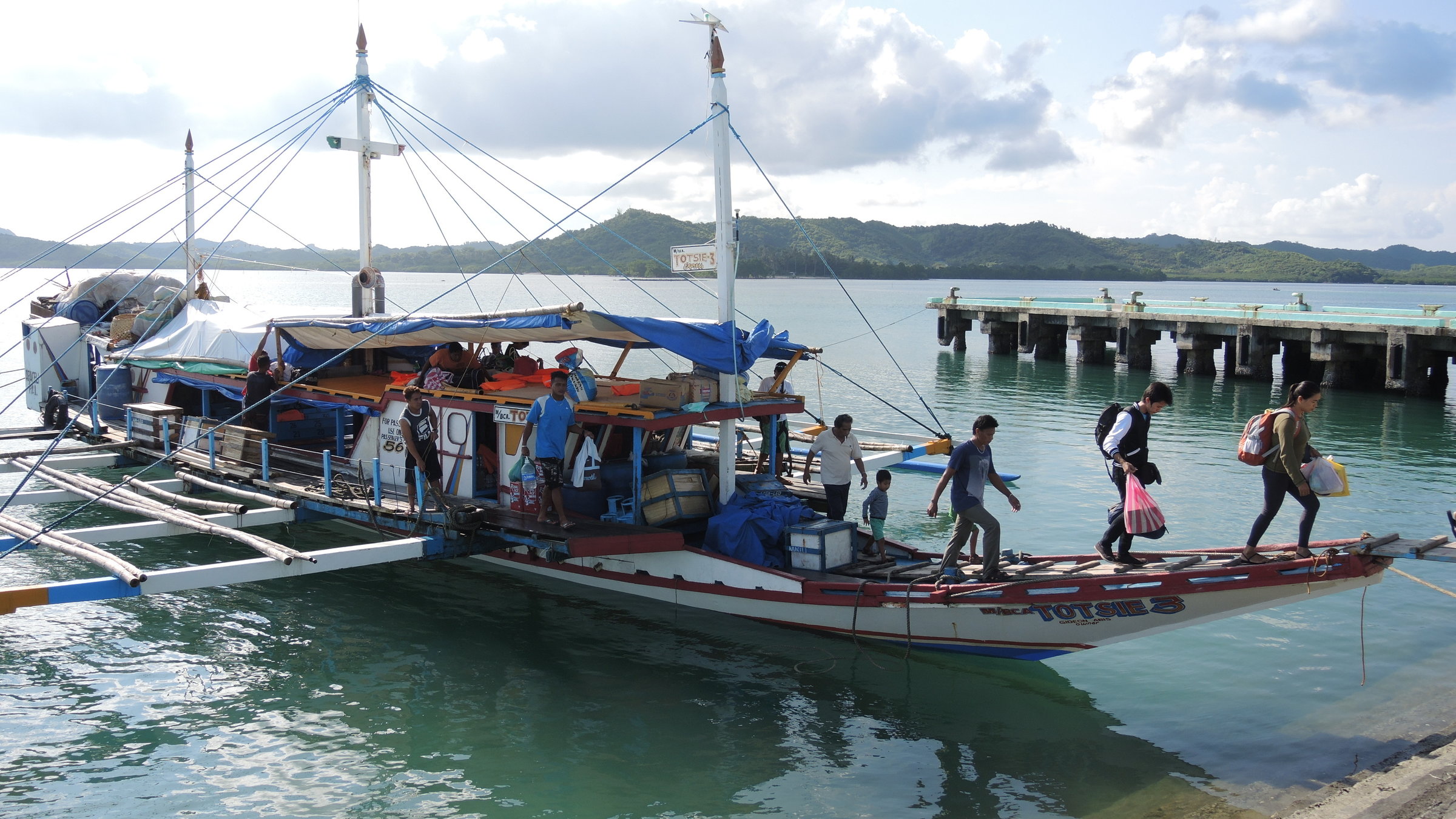 "Die schönsten Fährpassagen der Welt (1/3) - Philippinen - Mit Banca-Booten von Insel zu Insel": Banca-Boat-Fähre mit Passagieren die von Bord gehen.