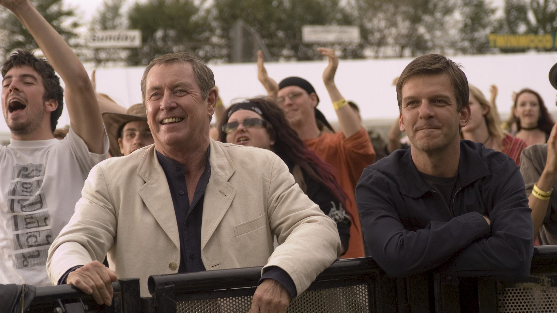 "Inspector Barnaby - Mord mit Groove": Barnaby (John Nettles) und sein Assistent Jones (Jason Hughes) stehen in einer jubelnden Menge und lächeln.