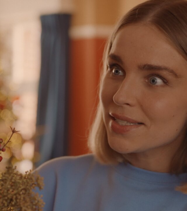 "Single Bells - 12 Dates till Christmas: Secret Santa": Mina (Julie Van den Steen) in Nahaufnahme. Sie schaut überrascht zur Seite.