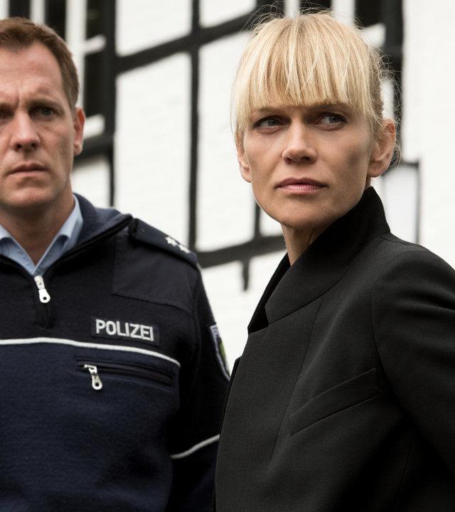 „Helen Dorn – Nach dem Sturm“: Tom Petersen (Johannnes Zirner) und Helen Dorn (Anna Loos) stehen nebeneinander im Freien vor einem weißen Haus.