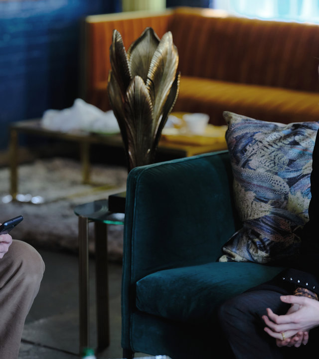 "Suspect - Folge 2: Nicola": Danny (James Nesbitt) und Nicola (Niamh Algar) sitzen sich im Wohnzimmer gegenüber. Danny schaut auf den Bildschirm eines Smartphones in seiner Hand, Nicola sieht ihm dabei zu.