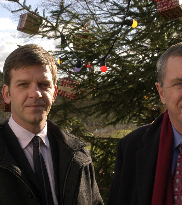 "Inspector Barnaby - Ein missratener Sohn": DS Ben Jones (Jason Hughes) und DCI Tom Barnaby (John Nettles) kommen am Tatort an. Im Hintergrund ist ein großer geschmückter Tannenbaum zu sehen.
