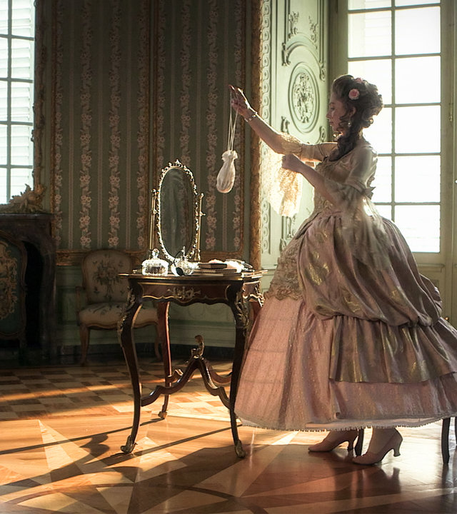 "Die glorreichen 10 - Die krassesten Modetrends der Geschichte": Madame de Pompadour in einem Schloss. Sie steht in einem üppigen Barockkleid vor ihrem Schminktisch.