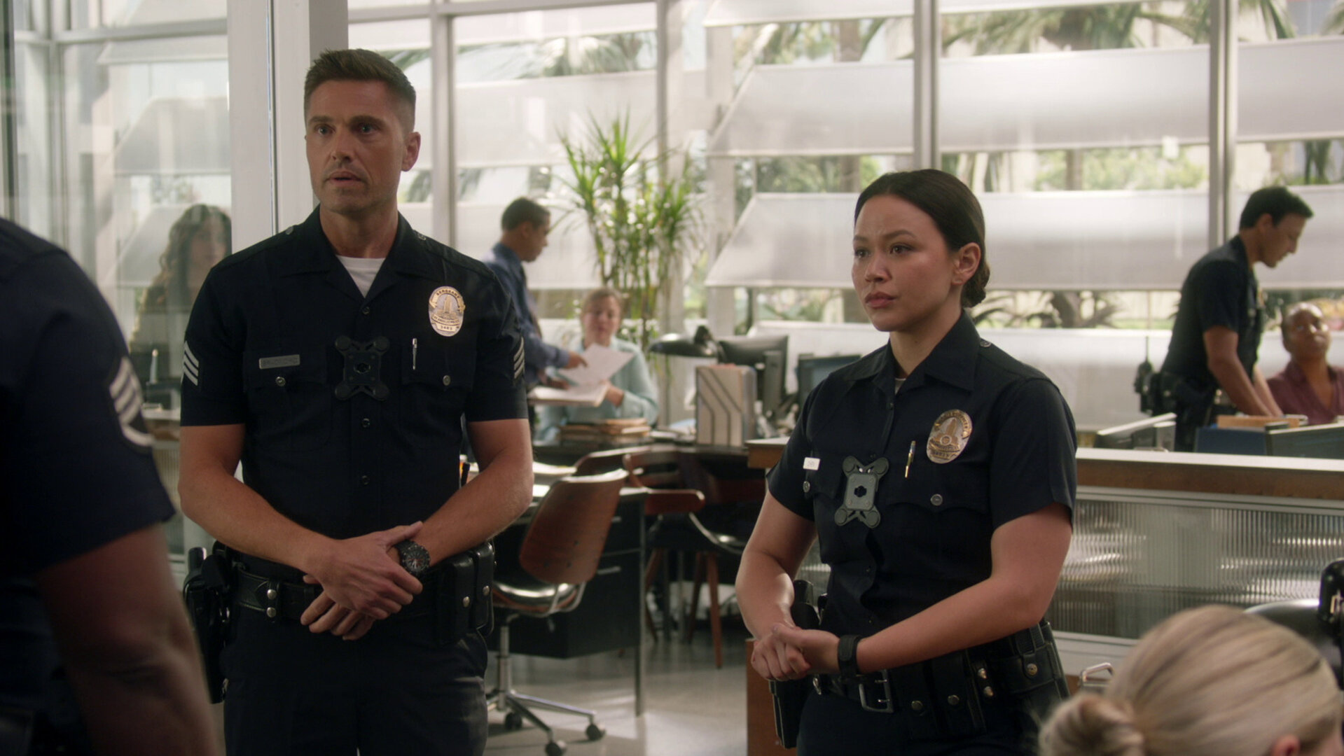"The Rookie - Das Halsband": Im Büro der Polizeistation stehen Officer Lucy Chen (Melissa O'Neil) und Tim Bradford (Eric Winter) ihrem Vorgesetzten Officer Grey (Richard T. Jones) verlegen gegenüber.
