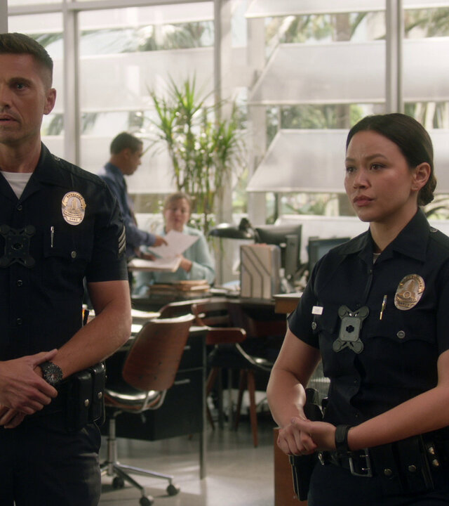 "The Rookie - Das Halsband": Im Büro der Polizeistation stehen Officer Lucy Chen (Melissa O'Neil) und Tim Bradford (Eric Winter) ihrem Vorgesetzten Officer Grey (Richard T. Jones) verlegen gegenüber.
