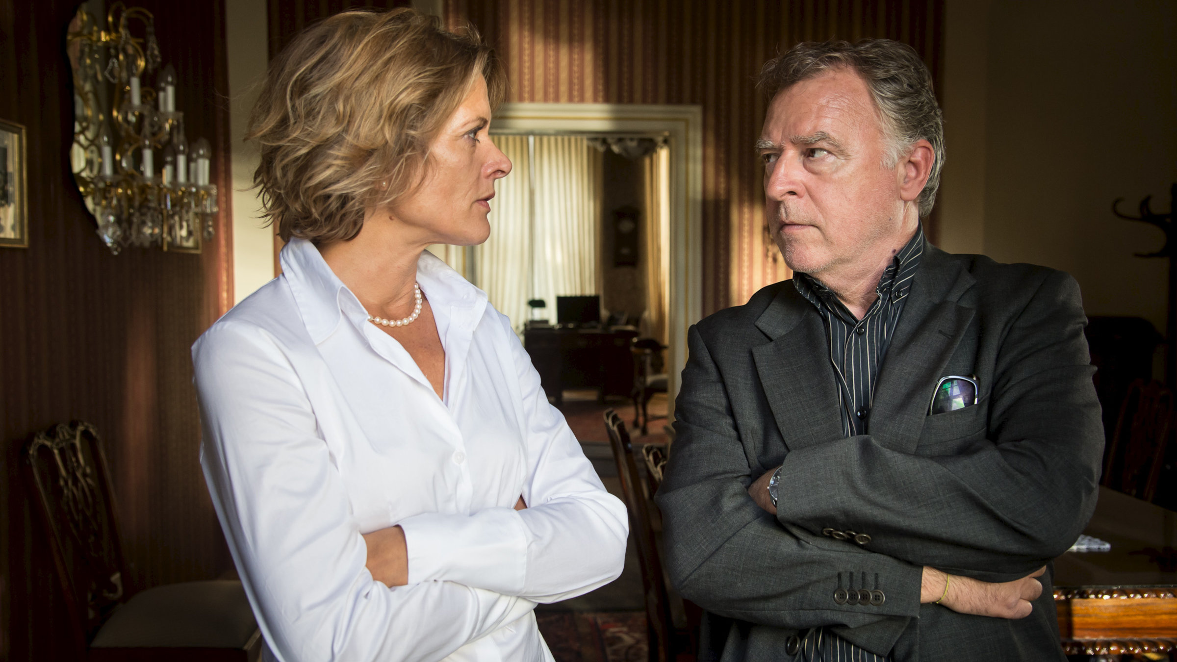 "SOKO Leipzig: Graf Porno": Gräfin Thurmstein (Karin Giegerich) und Hajo  (Andreas Schmidt-Schaller) stehen nebeneinander und schauen sich ernst an. Beide haben die Arme verschränkt.