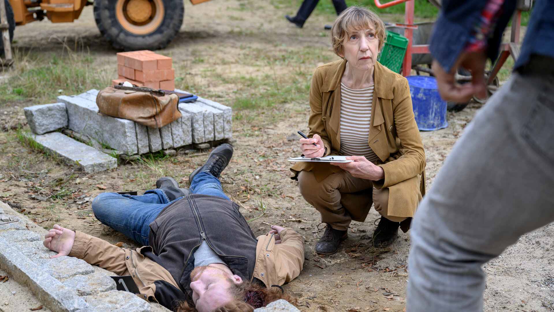 „SOKO Wismar – Trautes Heim“: Auf einer Baustelle: Rechtsmedizinerin Dr. Helene Sturbeck (Katharina Blaschke) untersucht am Tatort die Leiche von Leo Schallenberg (Komparse).