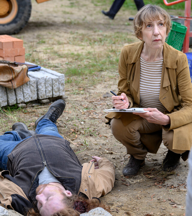 „SOKO Wismar – Trautes Heim“: Auf einer Baustelle: Rechtsmedizinerin Dr. Helene Sturbeck (Katharina Blaschke) untersucht am Tatort die Leiche von Leo Schallenberg (Komparse).