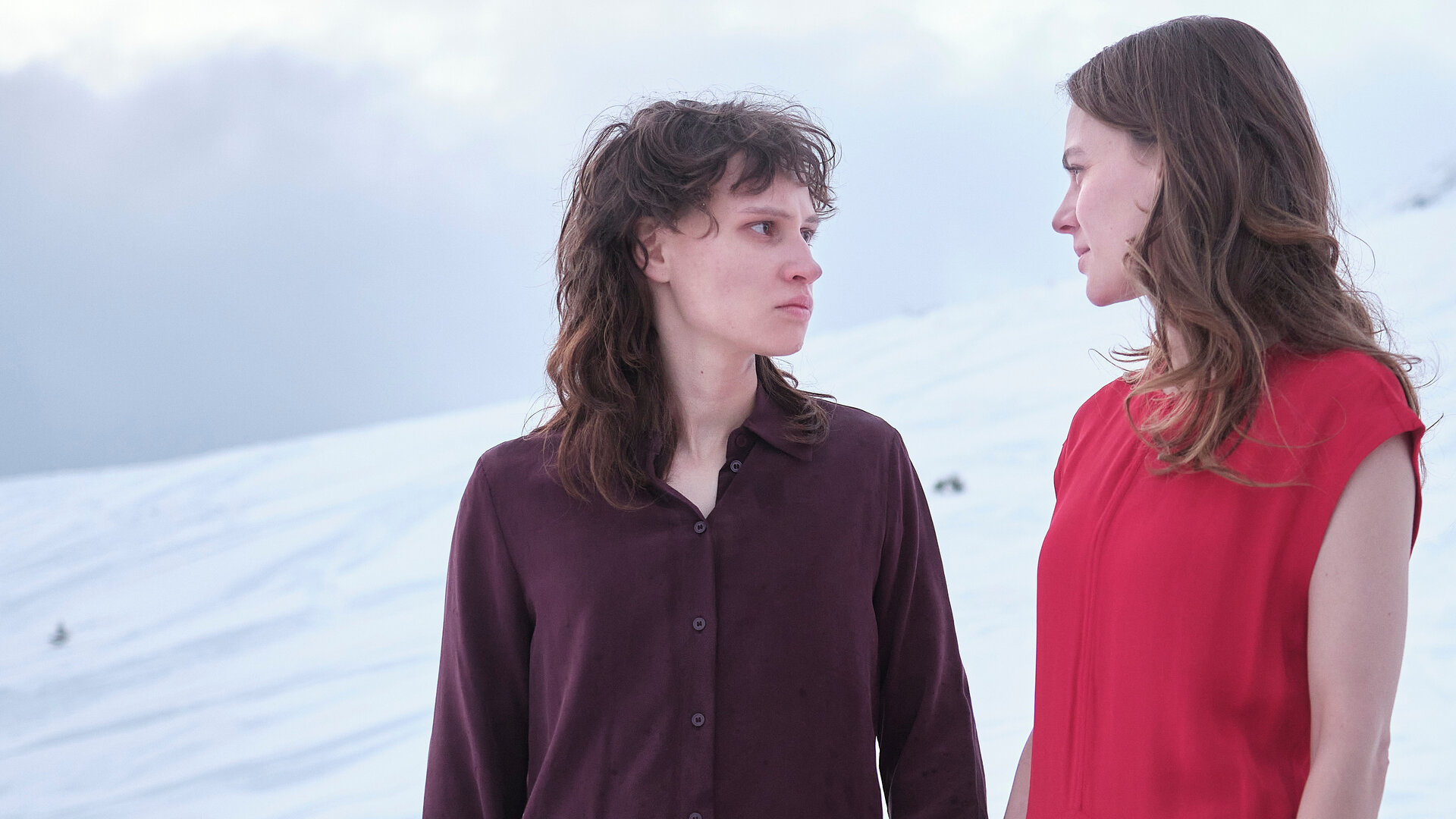 "WAKE UP - Atmen": Emilia (Luna Jordan,l.) und Clara (Alicia von Rittberg, r.) stehen vor einem verschneiten Hang und halten sich an den HÃ¤nden. Dabei blicken sie sich in die Augen.