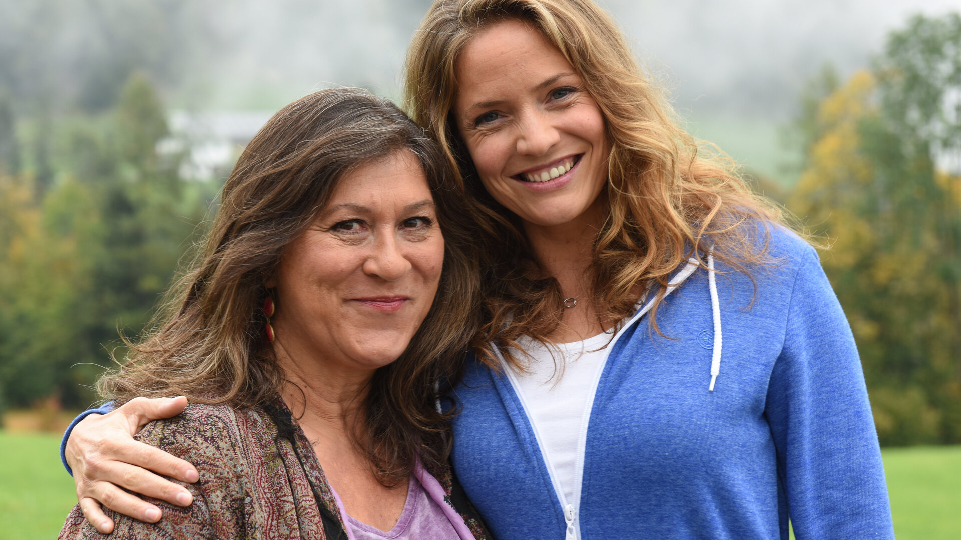 "Lena Lorenz - Entscheidung fürs Leben": Lena Lorenz (Patricia Aulitzky) und ihre Mutter Eva (Eva Mattes) stehen Arm in Arm nebeneinander. Die beiden stehen im Grünen und lachen in die Kamera.