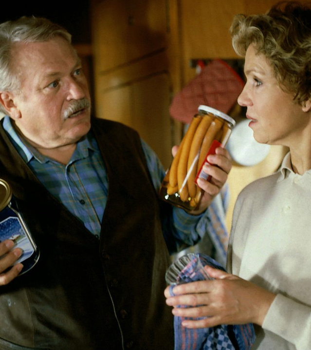 "Diese Drombuschs: Der Zerfall": Onkel Ludwig (Günther Strack) unterhält sich mit Vera (Witta Pohl) in seinem Wohnwagen. Er hält ein Glas mit Würstchen in der einen und eine Dose Kaffee in der anderen Hand.