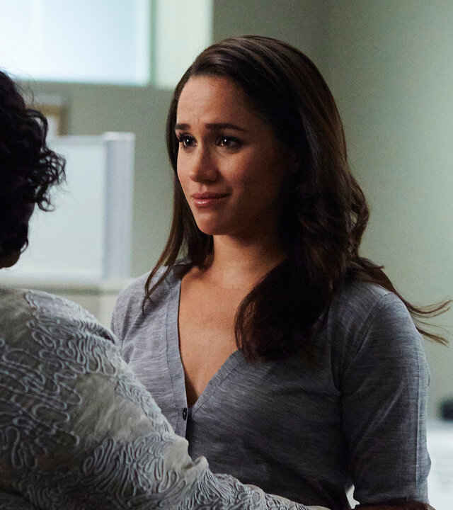 "Suits - Sie ist weg": Rachel (Meghan Markle) steht mit bedrückter Miene vor einer Frau, deren Rücken der Kamera zugewandt ist. Tröstend liegen deren Hände auf Rachels Armen und Rachel scheint für die trostspenden Worte sehr empfänglich.