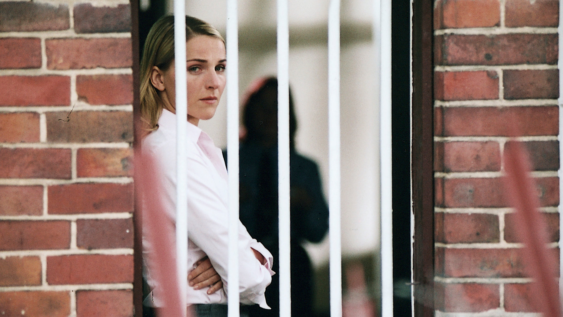 "Bianca - Wege zum Glück: Kapitel 147": Im Gefängnis: Bianca (Tanja Wedhorn) steht mit verschränkten Armen hinter einem vergitterten Fenster und schaut durch das Gitter hinaus. Sie wirkt belastet.