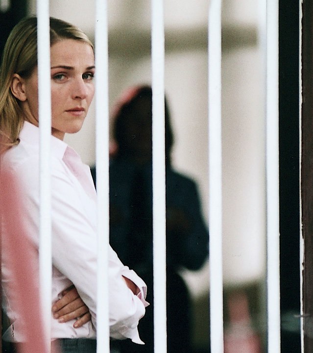 "Bianca - Wege zum Glück: Kapitel 147": Im Gefängnis: Bianca (Tanja Wedhorn) steht mit verschränkten Armen hinter einem vergitterten Fenster und schaut durch das Gitter hinaus. Sie wirkt belastet.
