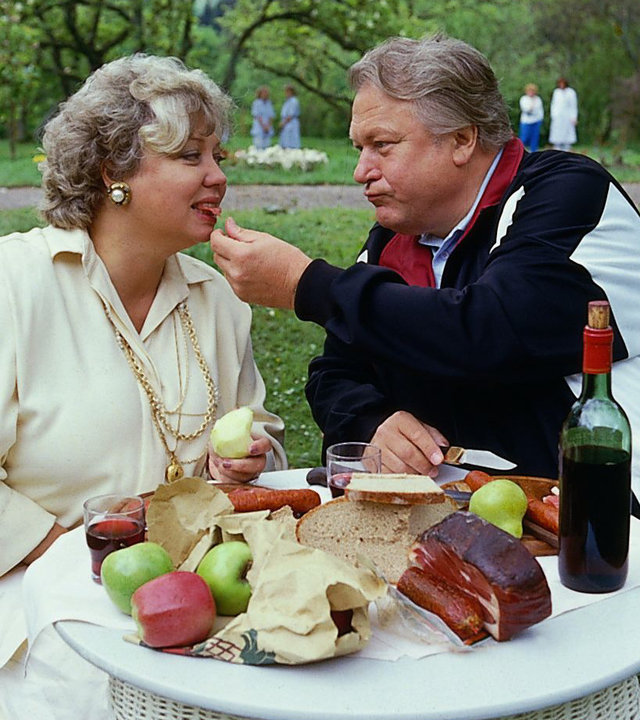"Die Schwarzwaldklinik - Gewichtsprobleme": Frau Kulmbach (Ilse Page) und Herr Kulmbach (Günter Strack) sitzen an einem reich bedeckten Tisch im Park und essen.