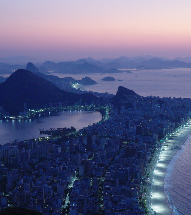"Megacitys - Wenn es Nacht wird in Rio de Janeiro": Panoramaaufnahme: Die Lichter der Stadt Rio de Janeiro leuchten in der Morgendämmerung.