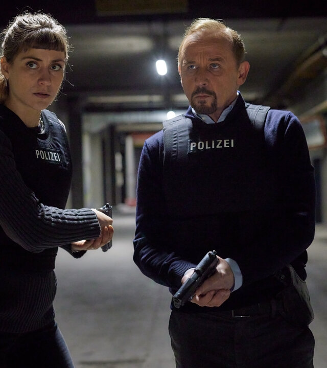 "Stralsund - Der letzte Sieg": Jule Zabek (Sophie Pfennigstorf) und Karl Hidde (Alexander Held) stehen mit gezogenen Waffen und schusssicheren Westen im Tunnelsystem.