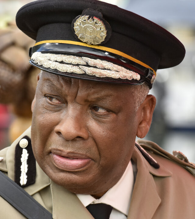 "Death in Paradise - Weihnachtsmänner in Gefahr": Commissioner Selwyn Patterson (Don Warrington) steht am Hafen. Er trägt eine helle Polizeiuniform sowie eine schwarze Dienstmütze. Kritisch blickt er zur Seite.