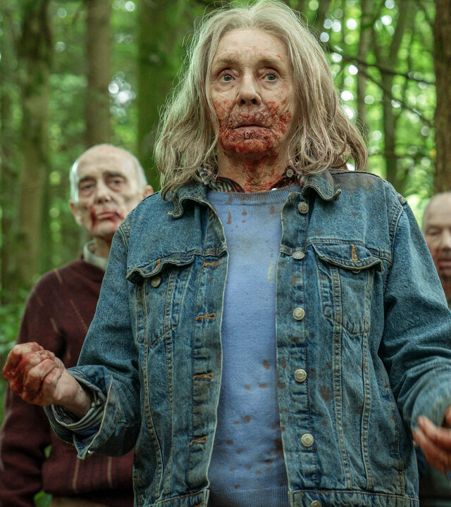 "Generation Z: Monsterparty": Cecily (Sue Johnston) geht durch einen Wald. Ihr Mund ist blutverschmiert. Hinter ihr sind weitere Senioren zu sehen.